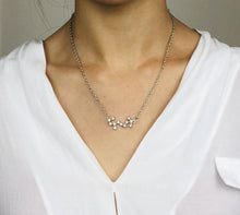 Load image into Gallery viewer, A Silver Scorpio Zodiac Sign Necklace is worn on a model. 
