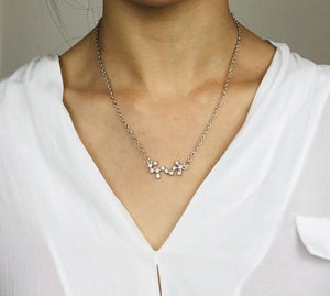 A Silver Scorpio Zodiac Sign Necklace is worn on a model. 