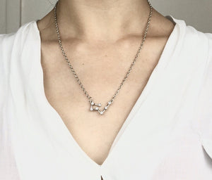 A Silver Taurus Constellation Sign Necklace is worn on a model. 