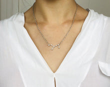 Load image into Gallery viewer, A Silver Virgo Zodiac Constellation Necklace is worn on a model.
