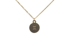 Load image into Gallery viewer, A zodiac symbol on the back side of a gold Gemini Zodiac Coin Necklace on a white ground.
