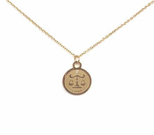 Load image into Gallery viewer, The front side of a gold Libra Medallion Necklace on a white background.
