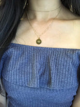 Load image into Gallery viewer, The back side of the Gold Aquarius Coin Necklace , layering with a dainty gold choker worn on a model. 
