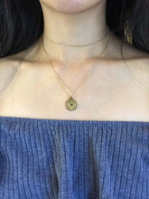 Load image into Gallery viewer, A gold Leo Zodiac Coin Necklace, paired with a dainty gold choker, worn on a model.
