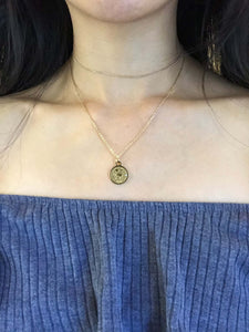 A gold Leo Zodiac Coin Necklace, paired with a dainty gold choker, worn on a model.