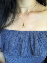 Load image into Gallery viewer, The front side of a gold Virgo Disc Necklace that features a lady-like symbol is worn on a model. 
